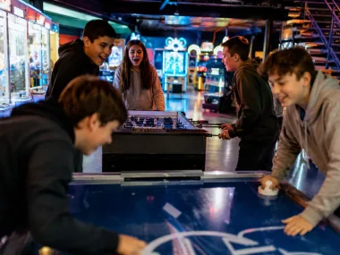 Jugendliche an Airhockey und Kicker in der Arcade (KI-Bild)